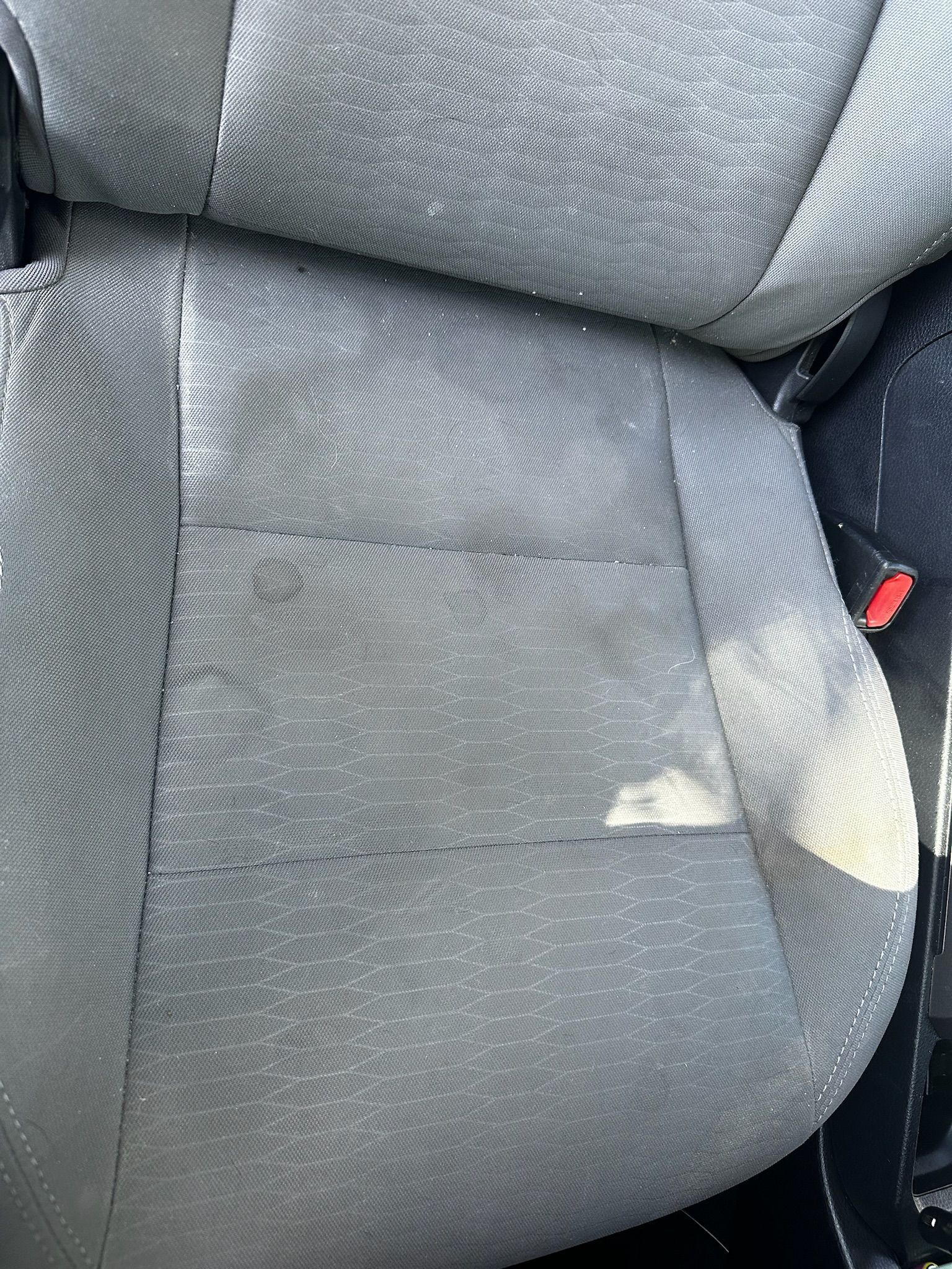 A close up of a car seat with a hole in it.