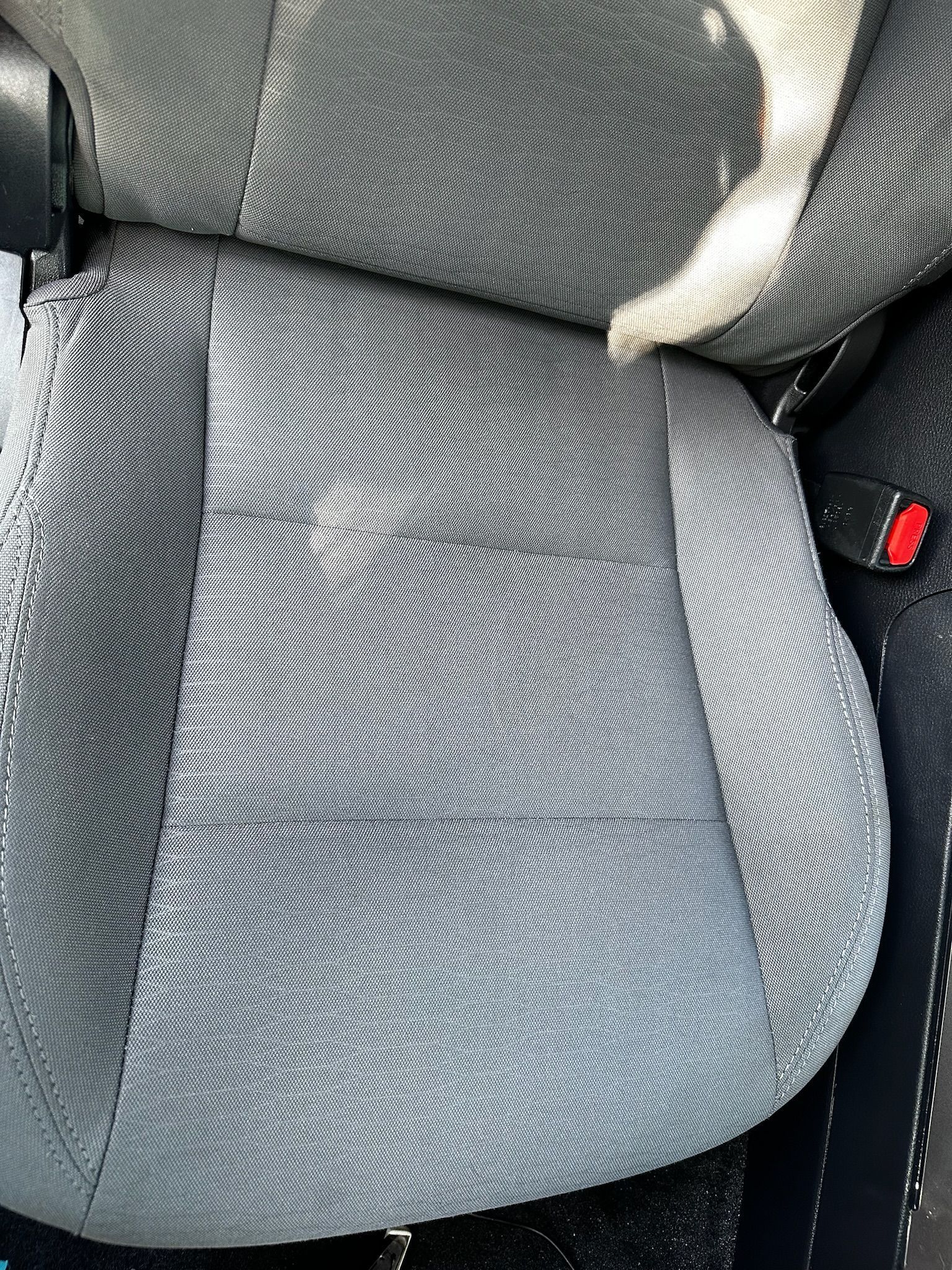 A close up of a gray seat in a car.